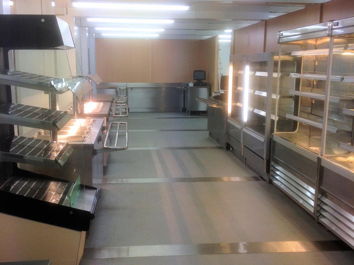 Self service area with refrigerated cabinets leading to a pay point and through to dining.